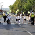A budaörsi Herman Ottó Általános Iskola diákjai rendőri segítséggel mennek át a zebrán az iskola közelében 2012. szeptember 3-án. MTI Fotó: Kovács Attila
