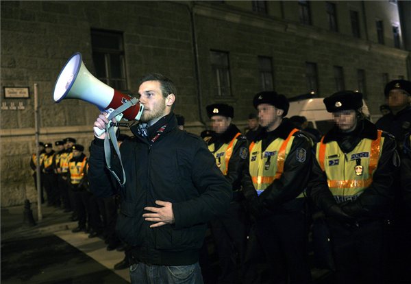 A tüntetés egyik moderátora felszólítja a politikusokat, hogy hagyják el a helyszínt az V. kerületi kapitányság előtt, ahol a tüntetők előállított társuk szabadon bocsátása érdekében demonstrálnak 2012. december 19-én. A fővárosba szervezett Téli Rózsás Diákforradalom folytatásaként a Lánchídon néhány száz diák gyűlt össze a felsőoktatás tervezett átalakítása miatti tiltakozásul. MTI Fotó: Beliczay László