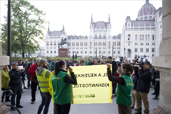 Greenpeace-aktivisták "EL A KEZEKKEL KISHANTOSTÓL!" feliratú transzparenst tartanak a Vidékfejlesztési Minisztérium előtt a Kettős Mérce blog demonstrációján 2014. április 12-én. A Fejér megyei településen az állami földpályázaton nyertes új bérlők elkezdték beszántani a korábbi - földpályázatokon vesztes - bérlő, a Kishantosi Vidékfejlesztési Központ Kft. által ősszel és tavasszal elvetett növényeket. MTI Fotó: Kallos Bea