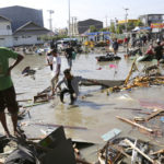 People survey the damage of the shopping mall following earthquakes and a tsunami in Palu, Central Sulawesi, Indonesia, Sunday, Sept. 30, 2018.  Rescuers try to reach trapped victims in collapsed buildings after hundreds of people are confirmed dead in a tsunami that hit two central Indonesian cities, sweeping away buildings with massive waves.(AP Photo/Tatan Syuflana)